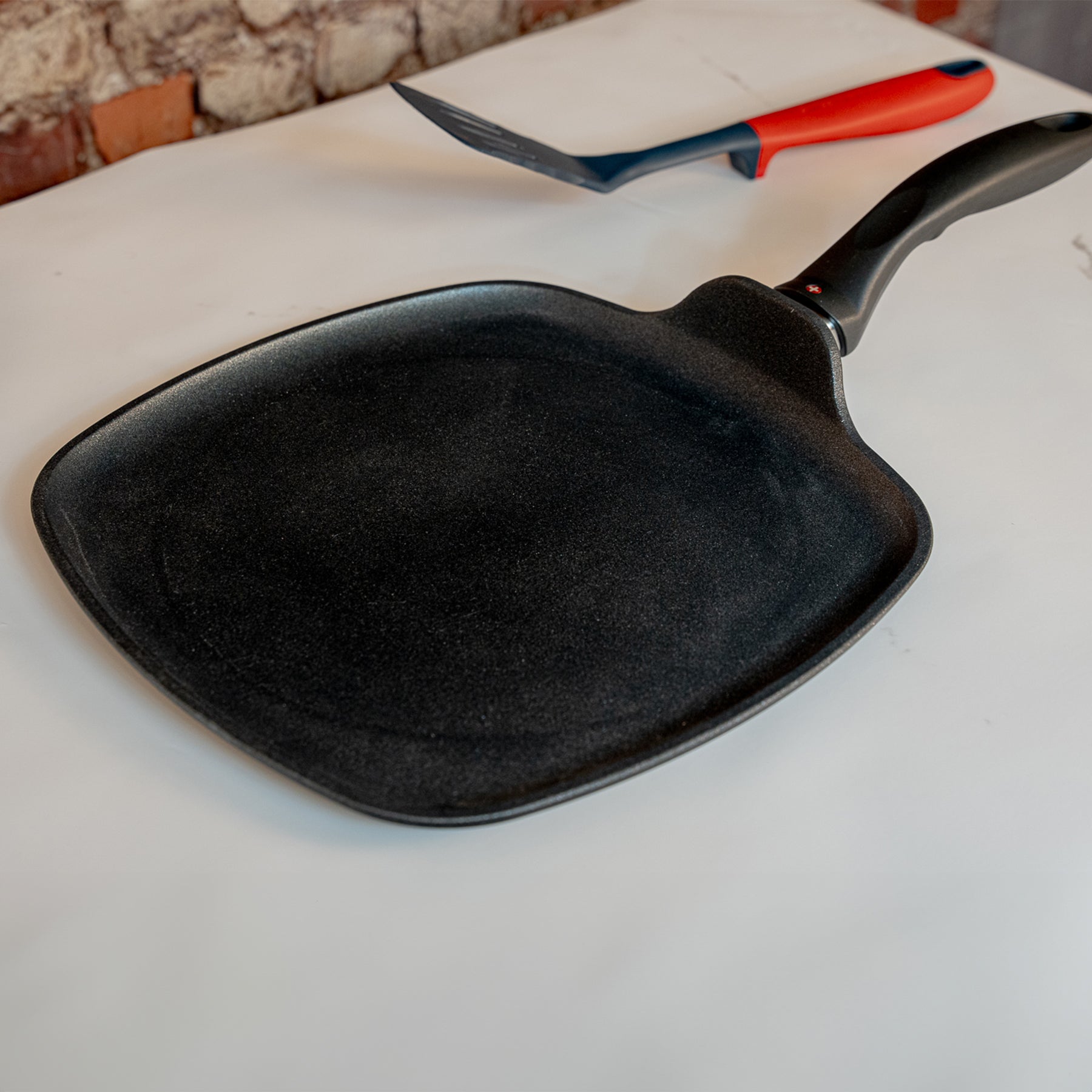 XD Nonstick 28 x 28 cm Square Griddle in use on marble counter