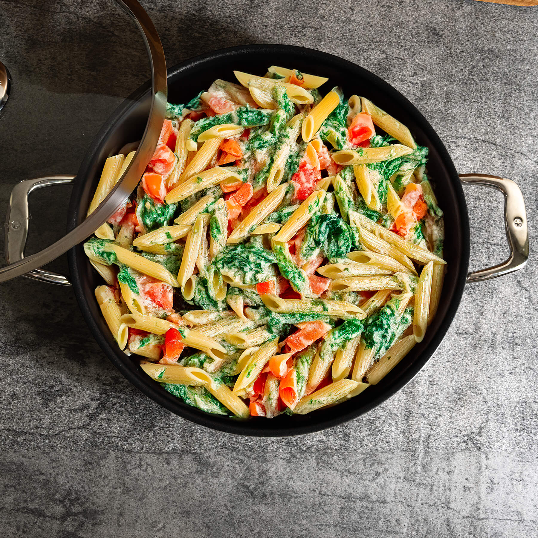 Nonstick Clad 5 L Stainless Chef's Pan with Glass Lid - Induction in use with food on kitchen counter