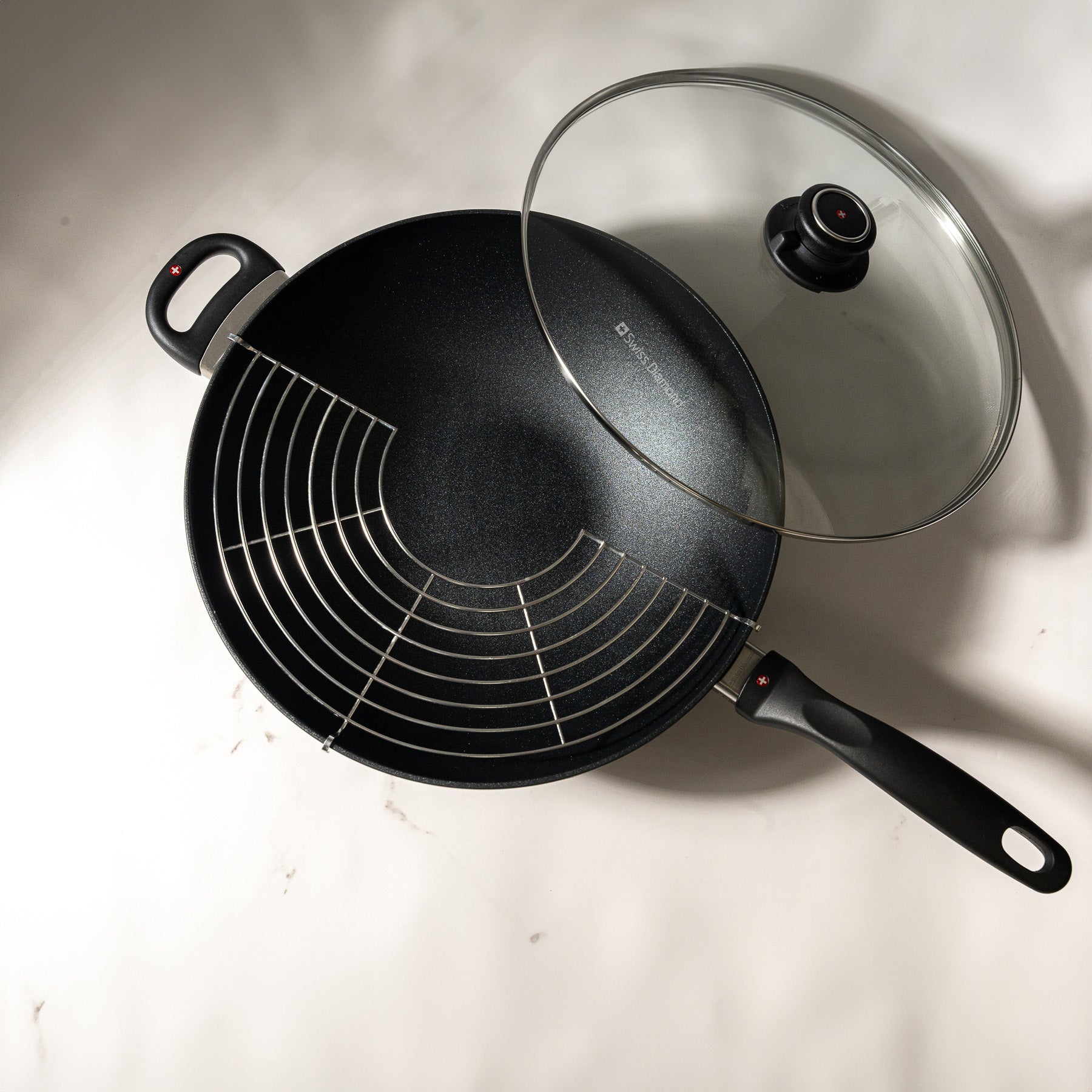 XD Nonstick 28 cm Wok with Glass Lid Top View and rack on the side on kitchen counter