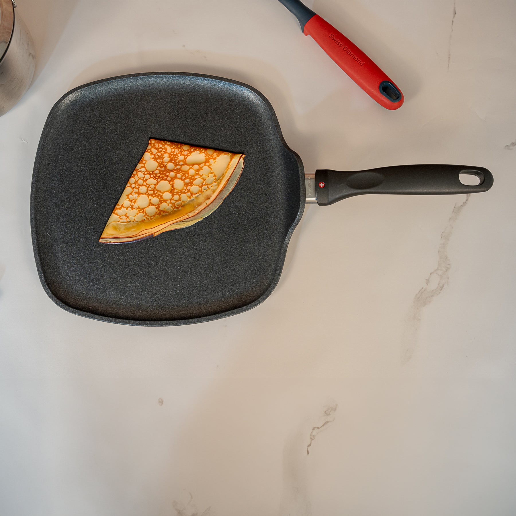 XD Nonstick 28 x 28 cm Square Griddle in use with folded crepe