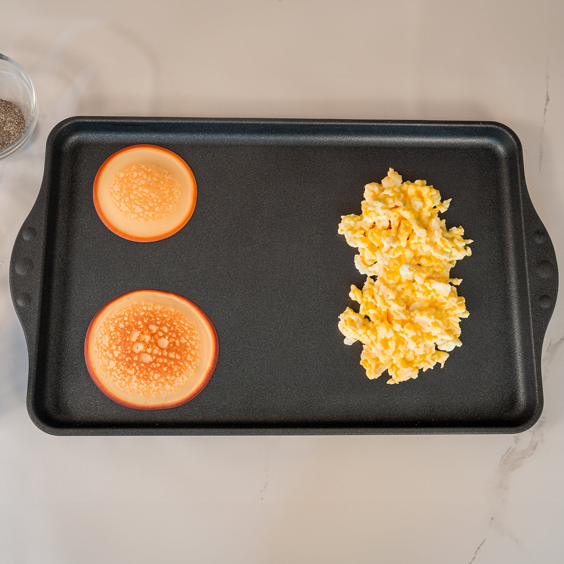 XD Nonstick 118 cm x 28 cm Double-Burner Griddle in use with pancakes and eggs on surface