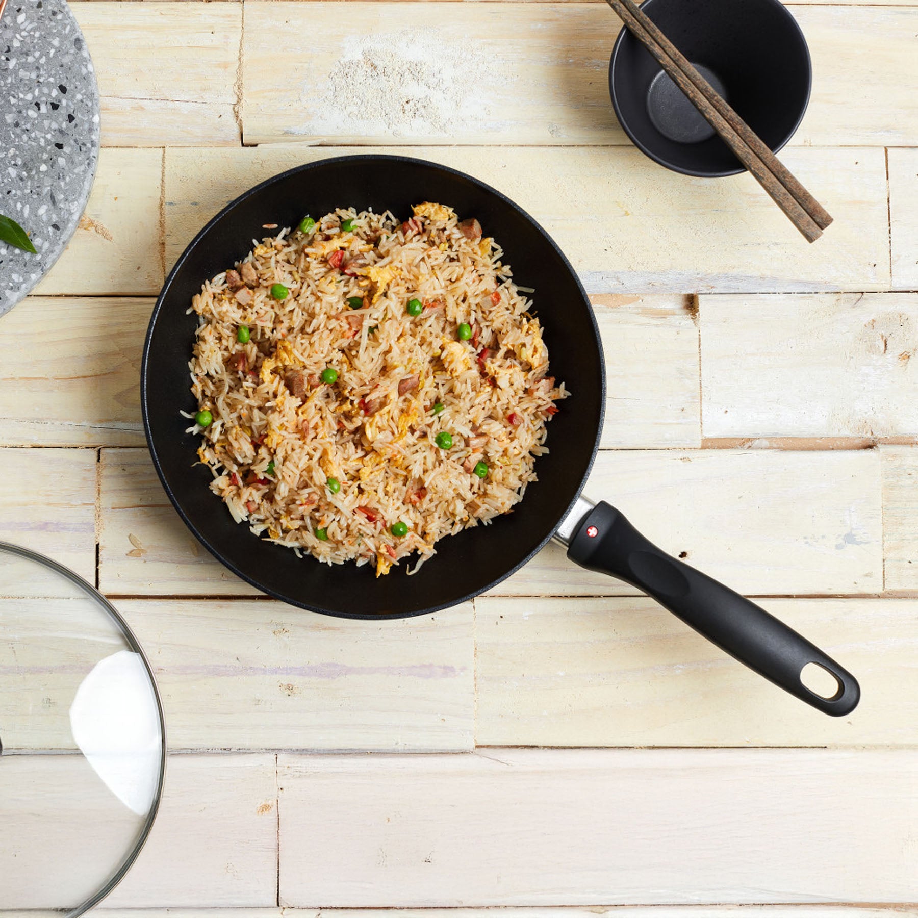 XD Nonstick Stir-Fry Pan with Glass Lid with food inside on wooden dining room table