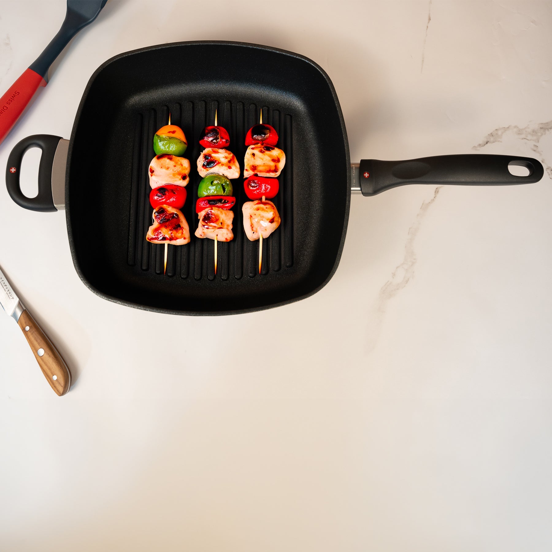 XD Nonstick 28 x 28 cm Deep Square Grill Pan - Induction in use with kabobs on surface