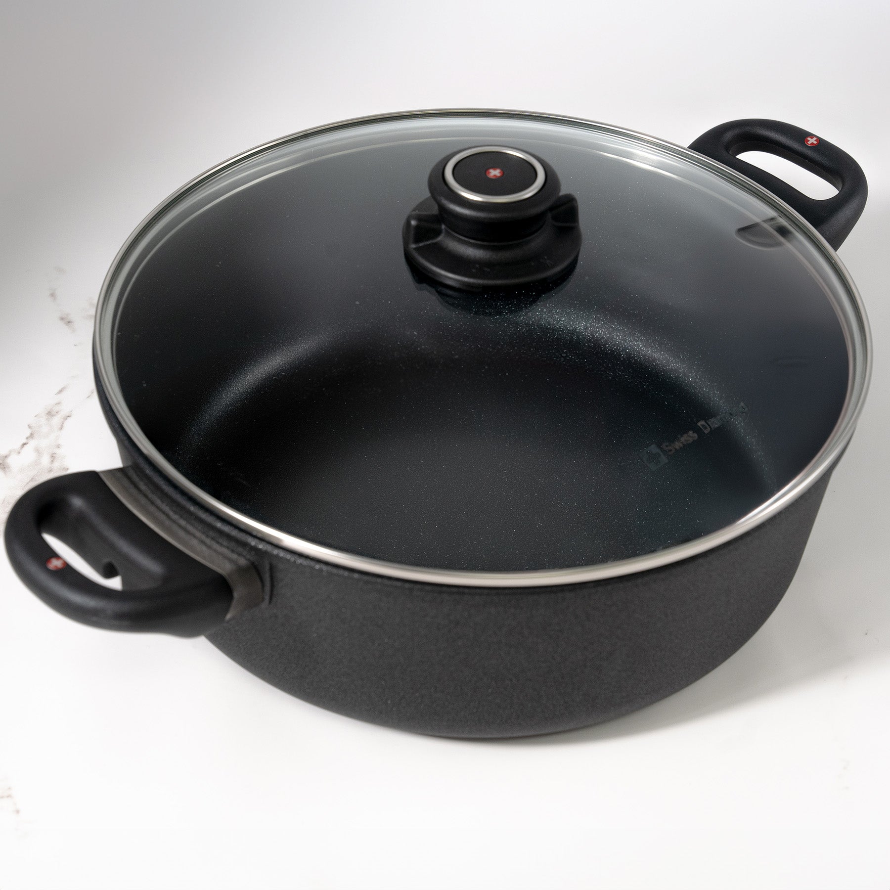 XD Nonstick Braiser with Glass Lid  top angle view on a marble kitchen counter